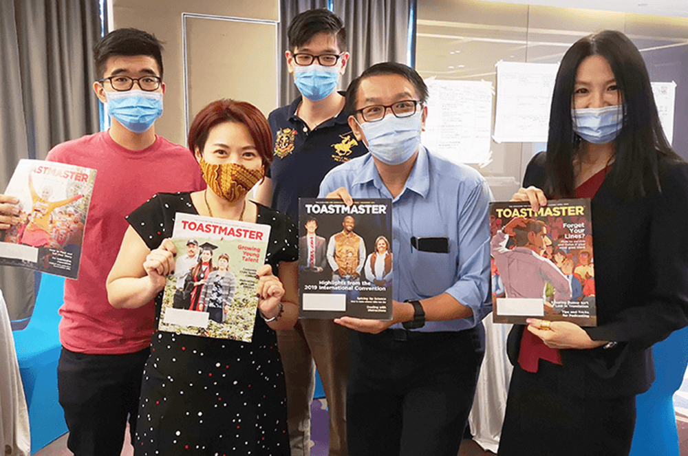 Group of people wearing medical masks holding magazines