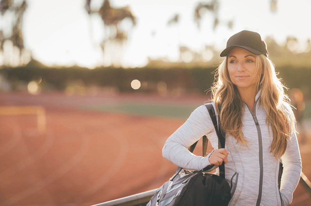 Woman holding bag near running track