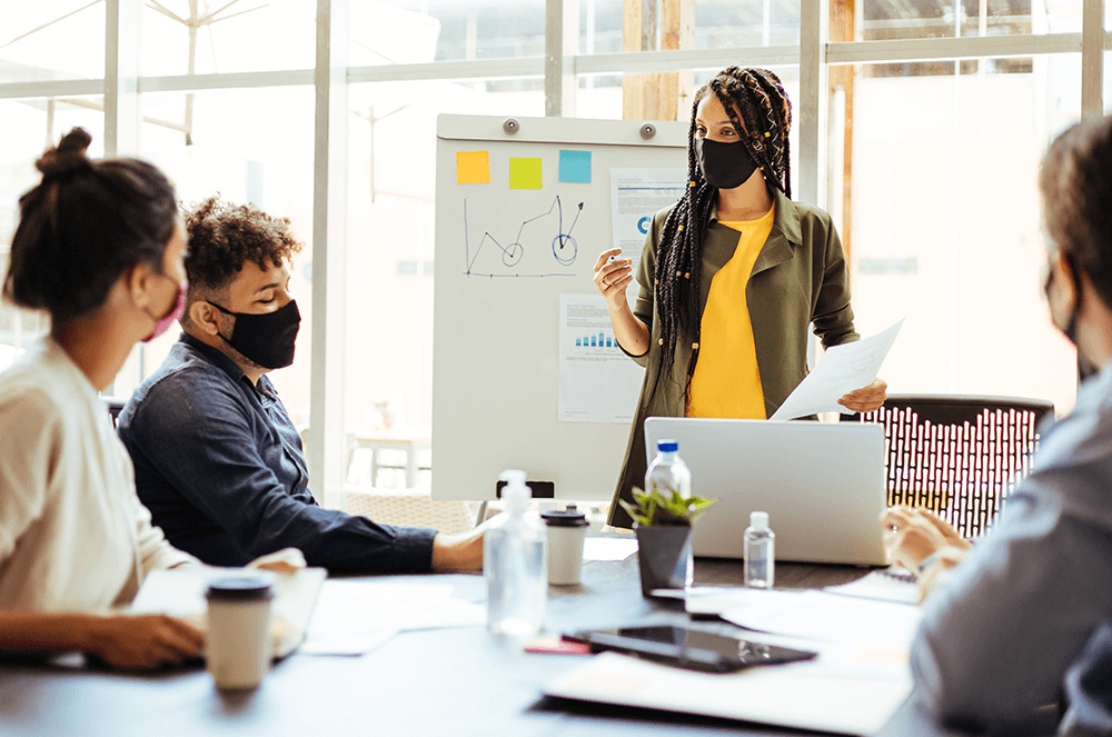 Workers having a meeting wearing masks